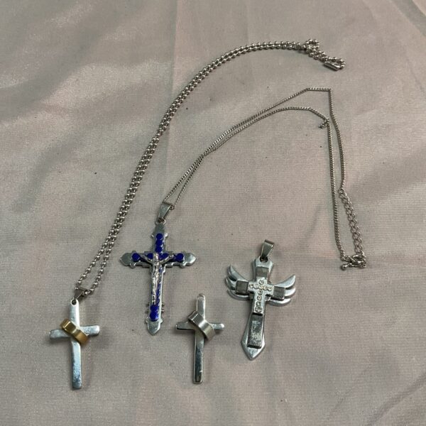 Vintage crucifix pendants with chains and ornate designs.