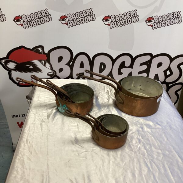 Lot of vintage copper pans with riveted handles.