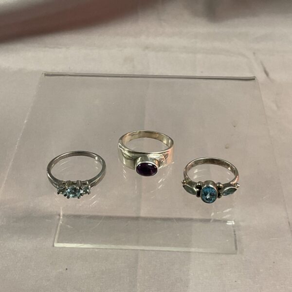 Close-up of three 925 silver rings with coloured stones.