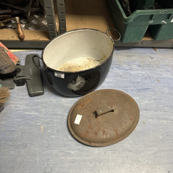 Vintage iron cooking pot with enamel interior, showing signs of wear.