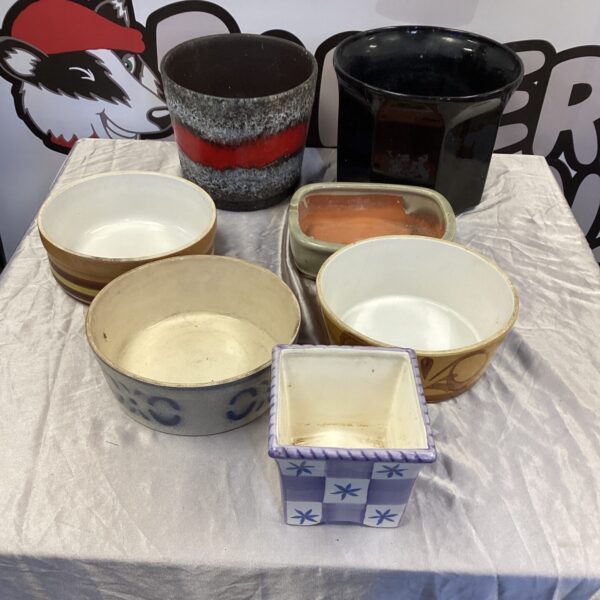 A lot of vintage ceramic flower pots in various colours and designs.