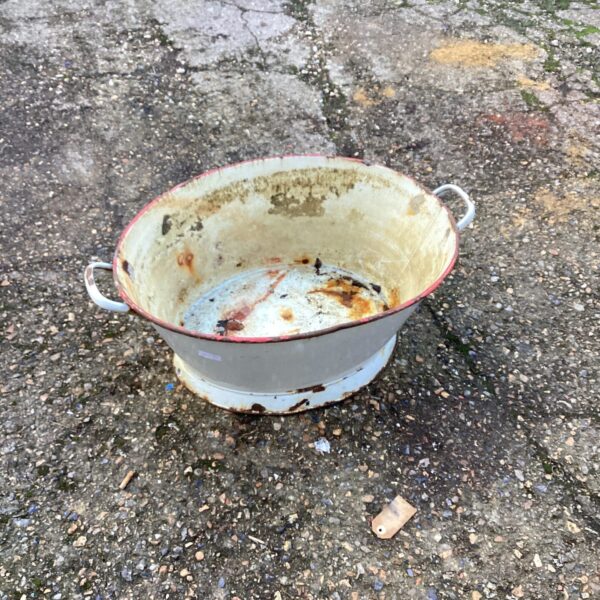 Vintage enamelled washing basin with signs of wear.
