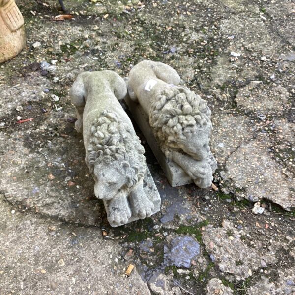 Pair of weathered stone garden lions for outdoor display.