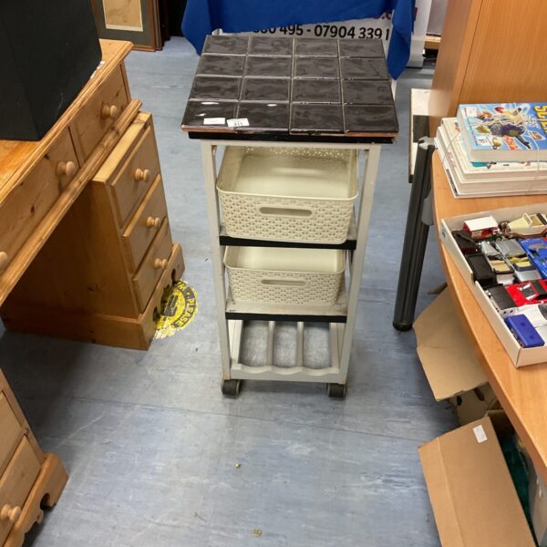 Vintage kitchen trolley with tiled top and drawers for storage.