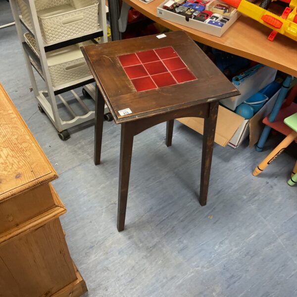 Vintage red tiled top table with dark wood legs.
