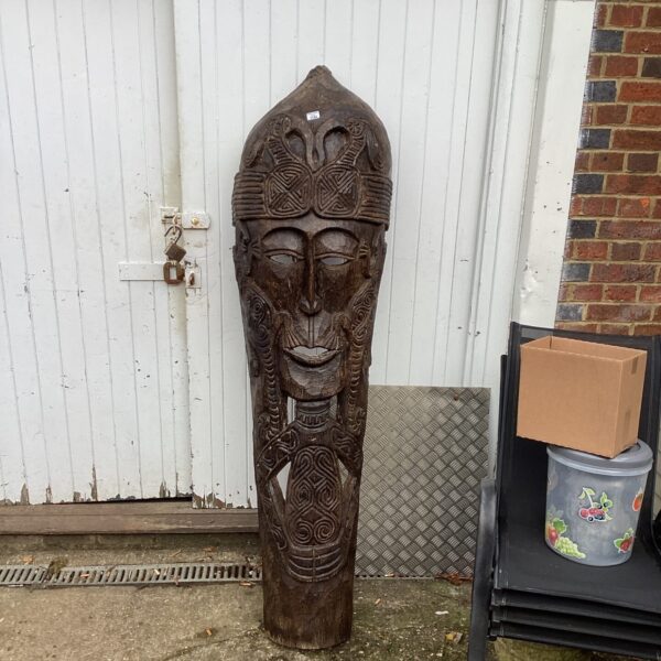 Large hand-carved wooden face mask with intricate geometric patterns.