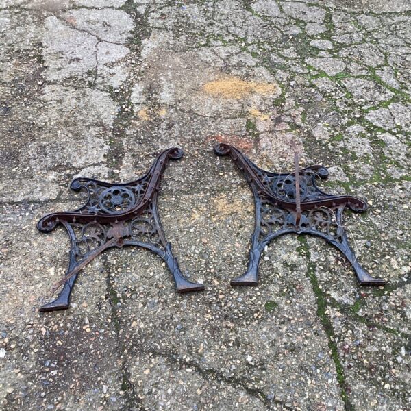 Antique wrought iron bench ends with Victorian floral design.