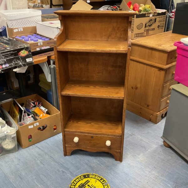 Wooden floor standing bookshelf with a single drawer for storage.
