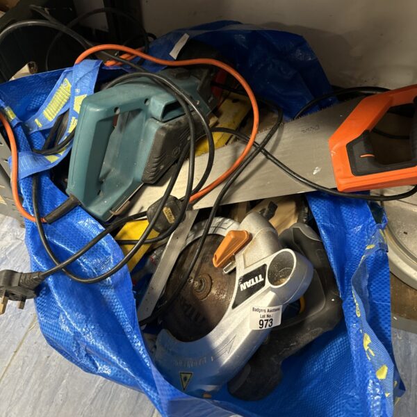 Blue bag filled with a variety of power tools and garden tools.