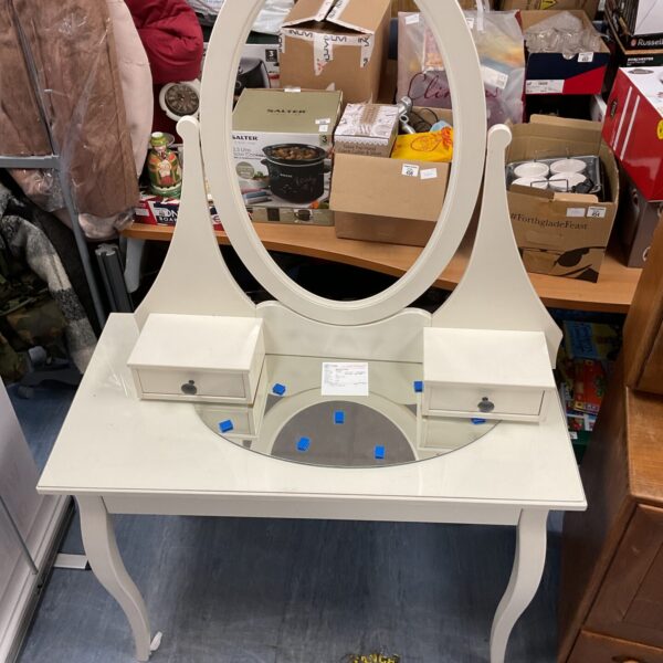 White dressing table with unfitted mirror in a bedroom setting.