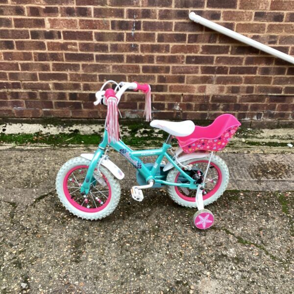 Pink and turquoise Apollo childs bike with streamers.