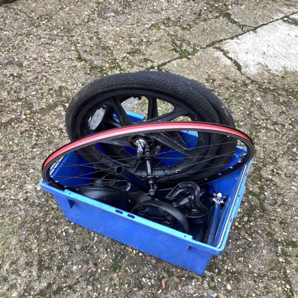 Used bicycle wheelset in a blue box, bike parts lot.