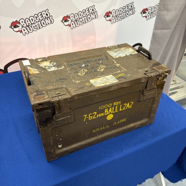 Front view of a weathered 7.62mm ammo tin with military markings.