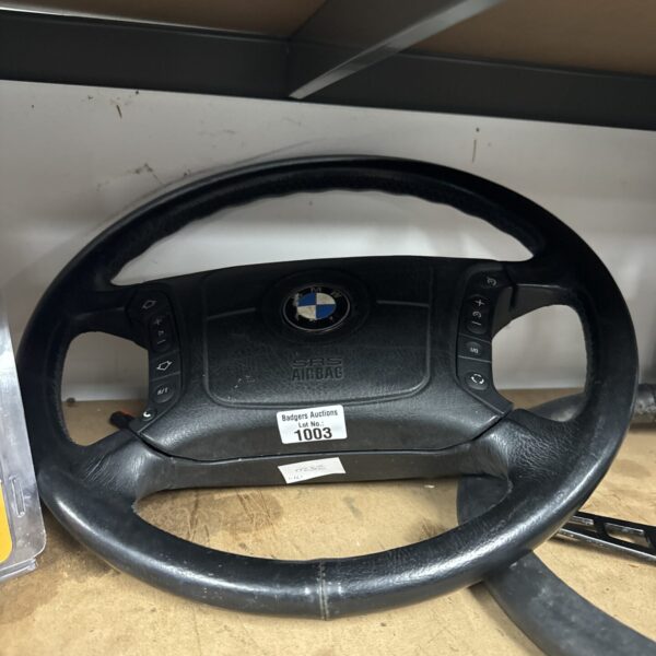 BMW E39 steering wheel with leather wrap and controls.