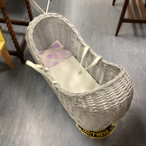 Vintage wicker baby cot with woven basket and classic design.