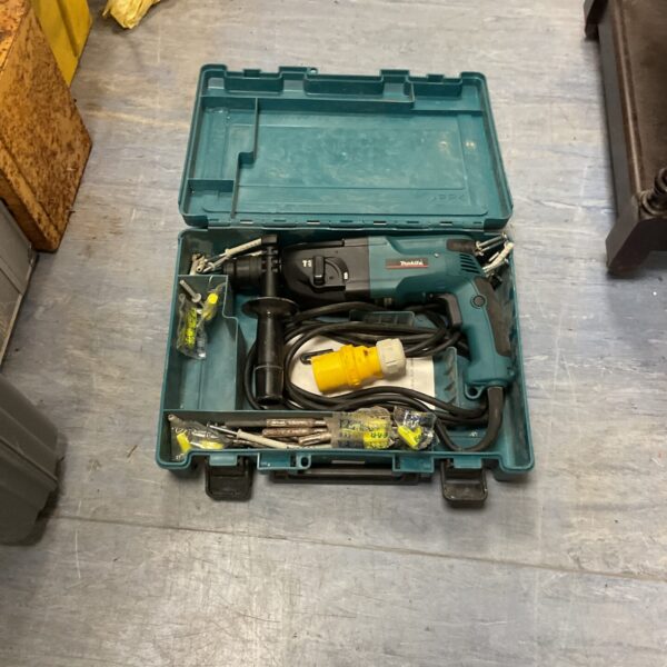 Makita 110v rotary hammer drill in open carry case, showing the tool and accessories.