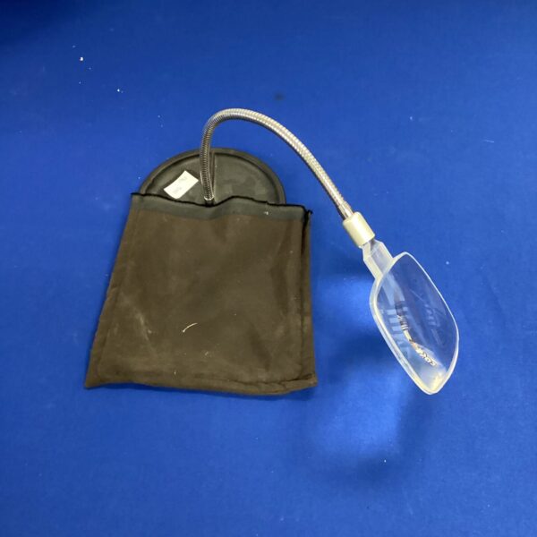 Vintage flexible magnifying glass on a dark surface.