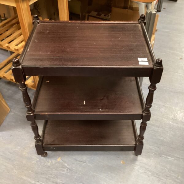 Dark wood butlers trolley with three tiers for serving.