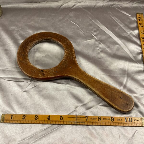 Large vintage wood magnifying glass with a wooden handle.