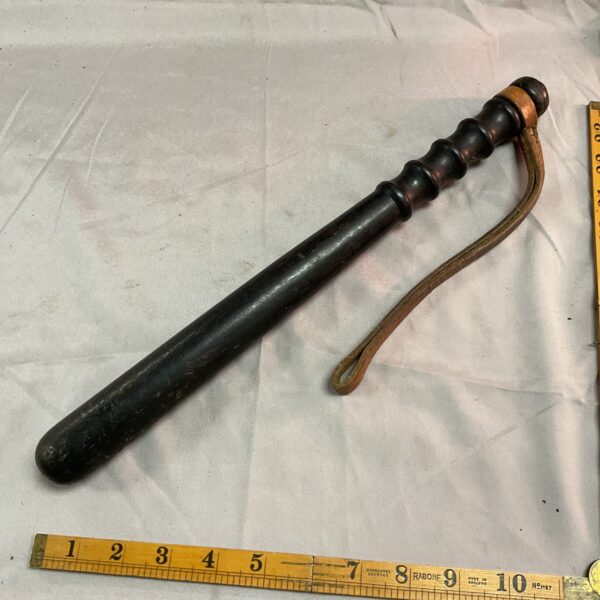 Vintage wooden police truncheon with leather strap.