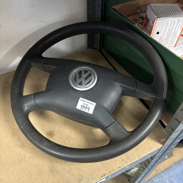 Grey Volkswagen steering wheel with VW logo.