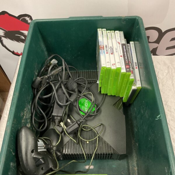 Xbox console with controller and collection of video games.