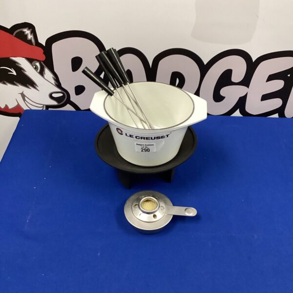Orange Le Creuset fondue set with fondue fork.