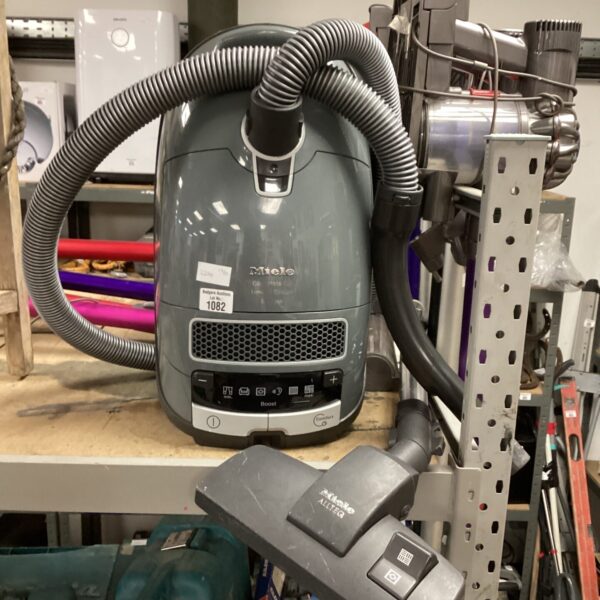 Miele C3 vacuum cleaner with hose and attachments.