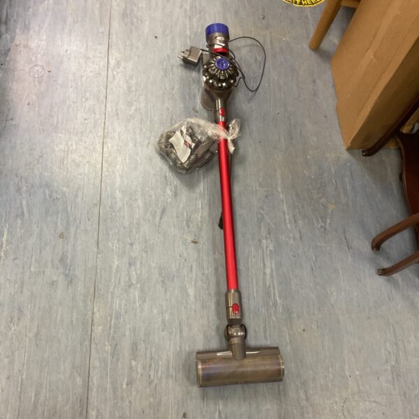 Dyson cordless vacuum cleaner with attachments for home cleaning.