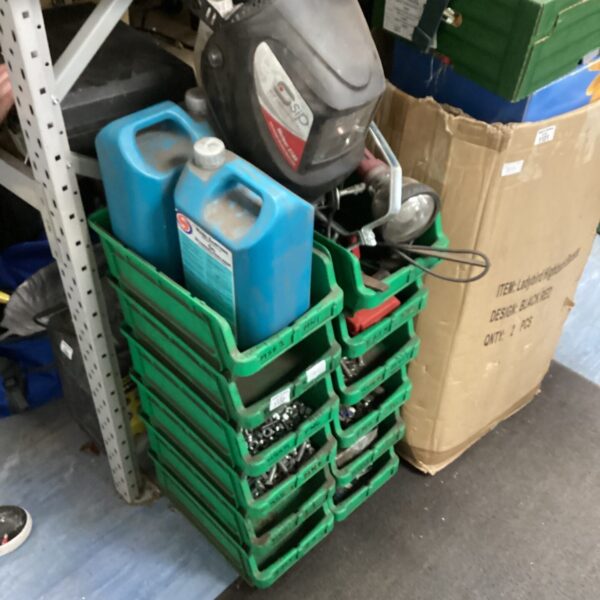 Green garage storage boxes containing a small engine and fluids.