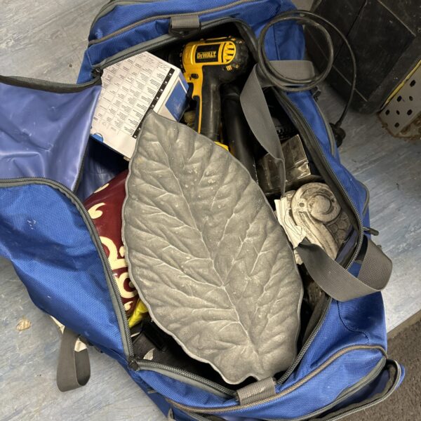 Blue tool bag with Dewalt cordless drill and assorted tools.