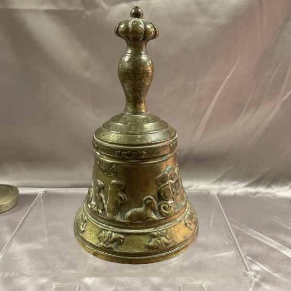 Vintage brass bell with detailed animal carvings, collectible desk decor.