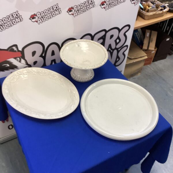Vintage white pottery dishes displayed on a blue surface.
