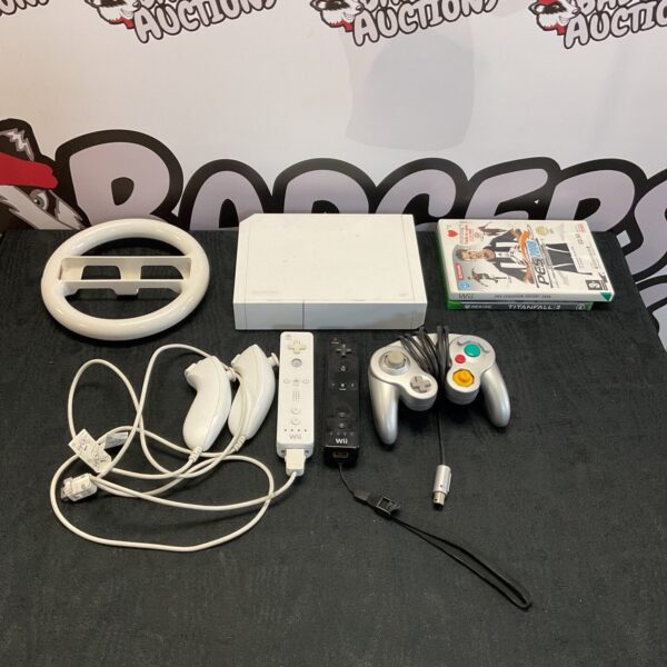 Nintendo Wii console with controllers and game, retro gaming setup.