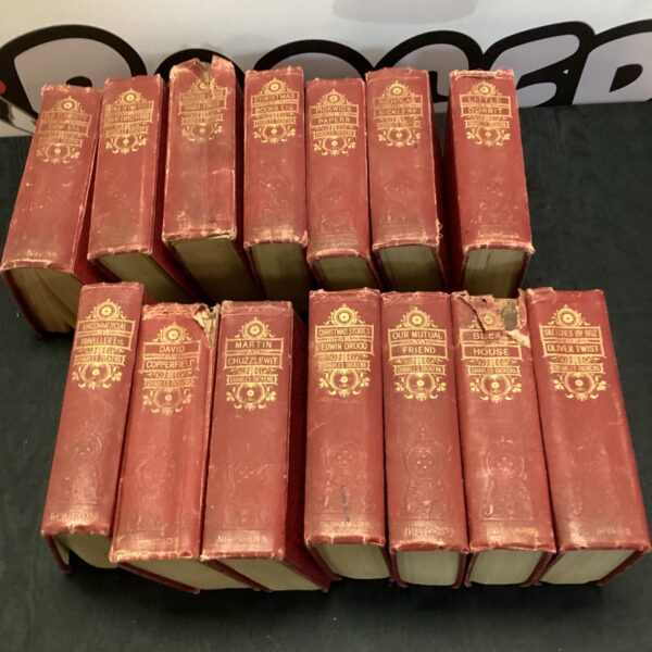 Collection of vintage Charles Dickens novels in red bindings.