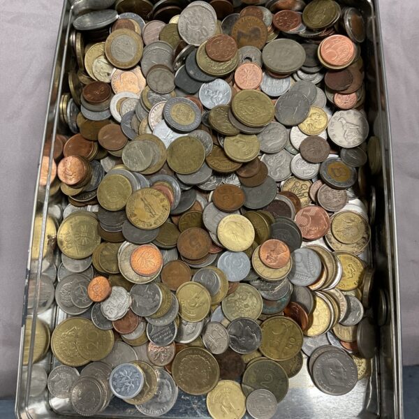 Metal tin filled with a diverse assortment of vintage and world coins.