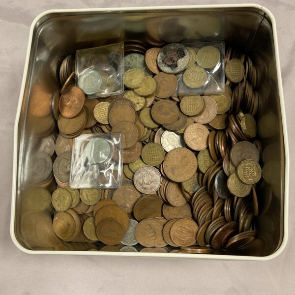 Assorted vintage coins in a metal tin for collectors.