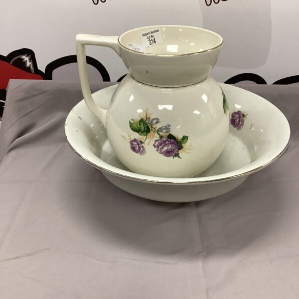 Vintage porcelain wash basin and jug set with floral design.