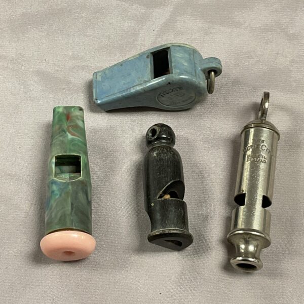 Vintage Bakelite whistles and Acme City whistle in a collectible lot.