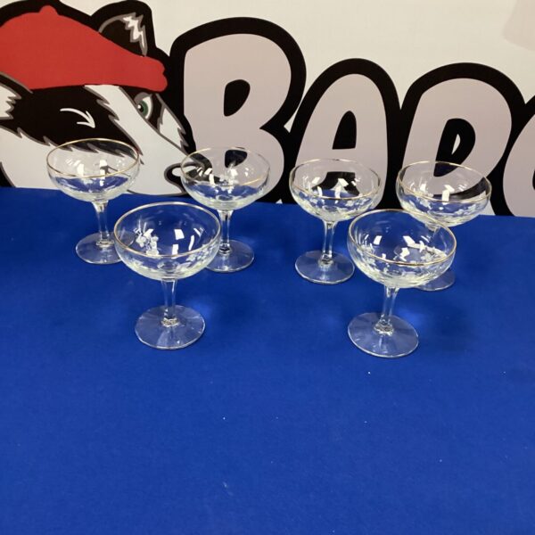 Six elegant crystal champagne glasses on a blue background.