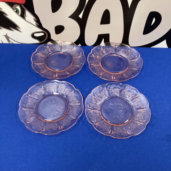 Vintage pink depression glass plate with floral design.