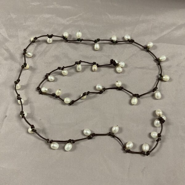 Close-up of a vintage pearl rope necklace with dark beads.