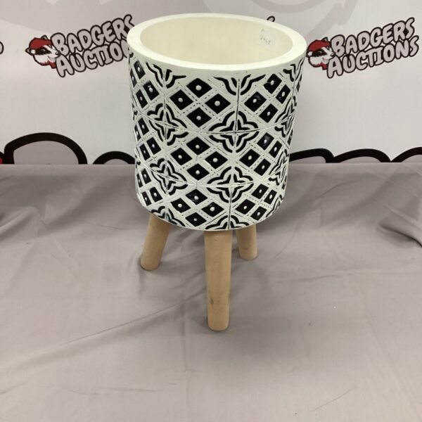 Vibrant Aztec patterned ceramic planter with wooden legs.