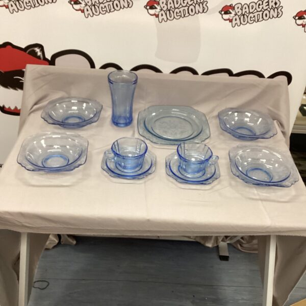 Vintage blue Depression glass dishes on a white surface.