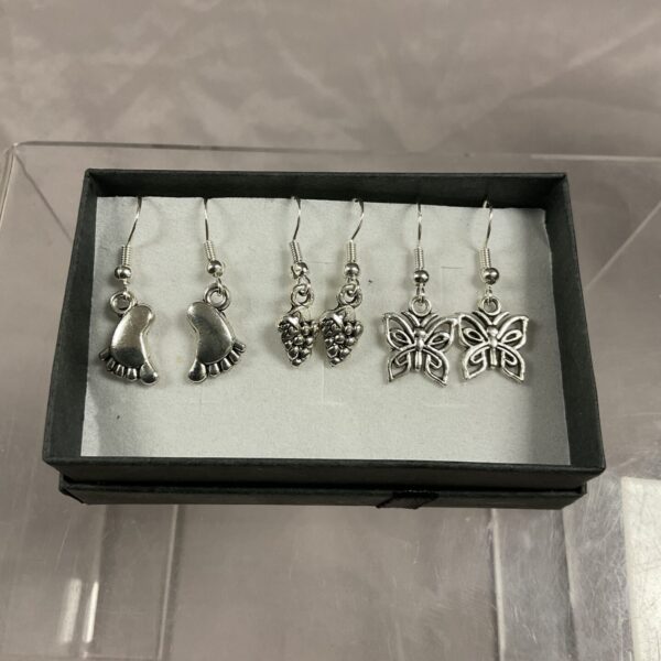 Close-up of three pairs of 925 silver floral earrings.
