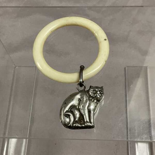 Antique silver baby rattle with a sculpted cat design.