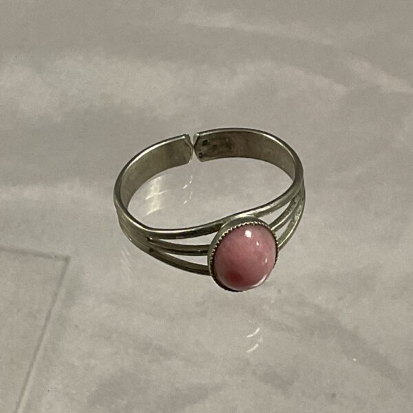 Silver tone ring with a pink stone, size R.
