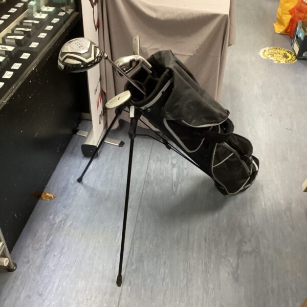 Black Slazenger golf bag with clubs standing on a floor.