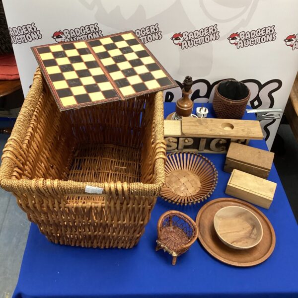 Vintage wicker basket filled with wooden items and a lamp.