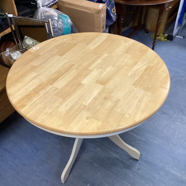 Vintage round farmhouse dining table with painted legs.